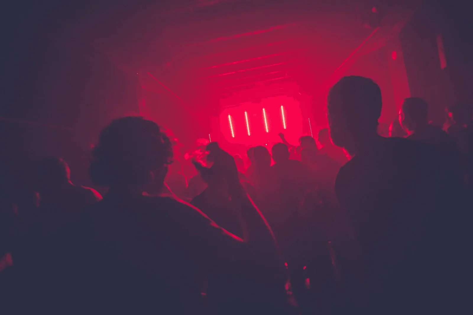 A crowded party lit in red light